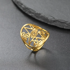 Golden cut-out star and eye pattern titanium steel open ring on a dark stone surface