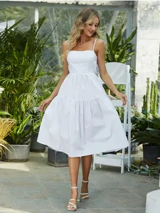 Detail view of a white bohemian sun dress with tiered skirt and elegant bow straps