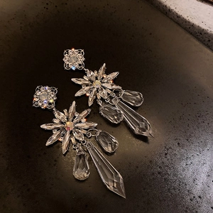 Macro shot of sparkling snowflake earrings with crystal fringe and silver finish detail
