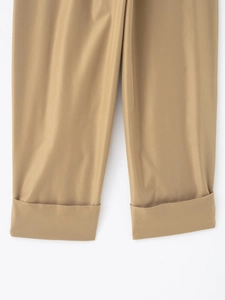 Detail of khaki twill trousers featuring stylish wide rolled-up cuffs and fabric texture