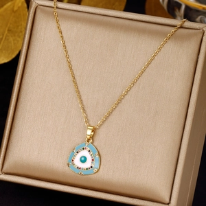 Golden evil eye necklace with blue enamel pendant and colorful zircons on a jewelry box