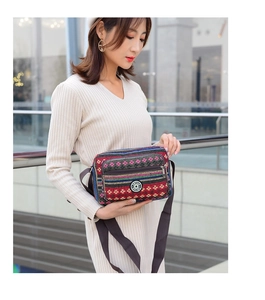 Detail of ethnic striped canvas crossbody bag with adjustable strap worn by model