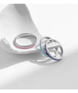 Detailed macro of three stackable S925 silver rings with enamel lines and sparkling zircons