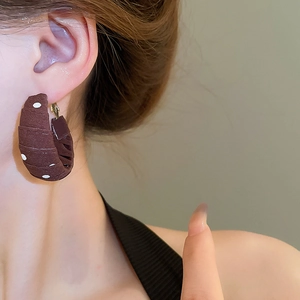 Detail of vintage polka dot fabric wrapped hoop earrings on a model showing fabric texture