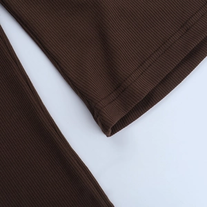 Detailed macro view of deep brown ribbed knit fabric with reinforced hem stitching
