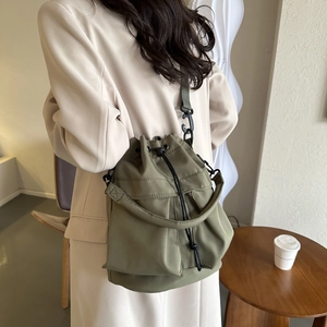 Détail du sac seau en nylon vert armée avec cordon de serrage et bandoulière réglable