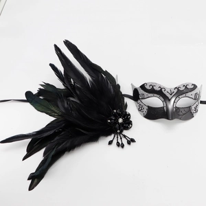 Détail du masque de fête argenté avec plumes noires et pendentifs perlés décoratifs