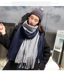 Detailed knit texture of a thick color-block scarf with grey and blue fringe tassels