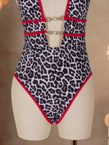 Detail of leopard print swimsuit featuring pearl metal accents and red piping trim