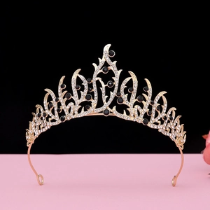 Detail of baroque vintage golden crown with black gemstones and white crystals