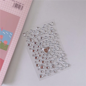 Detail of heart and round crystal acrylic gems on transparent sheet for DIY decor