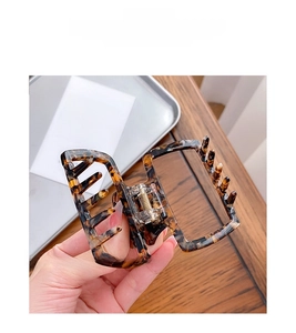 Detail view of square leopard print acetate hair claw clip with smooth metal spring mechanism