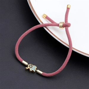 Close-up of pink adjustable cord bracelet featuring a gold-plated elephant charm