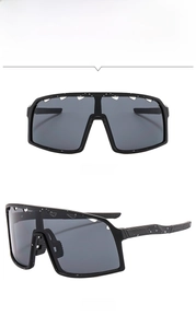 Detail view of black cycling sunglasses with air vents and white splatter pattern