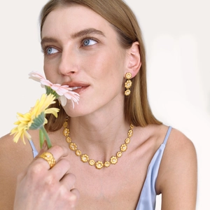 Nahaufnahme des goldenen Gänseblümchen-Schmucksets mit Kette Ohrringen und Ring