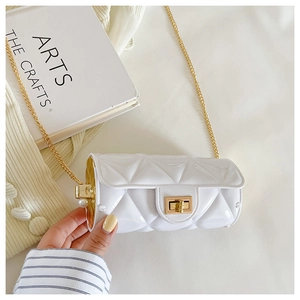 Detail of white quilted cylinder bag with gold chain strap and pearl accent