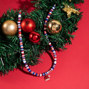 Macro detail of Christmas necklace with colorful glass beads and rhinestone Santa hat charm