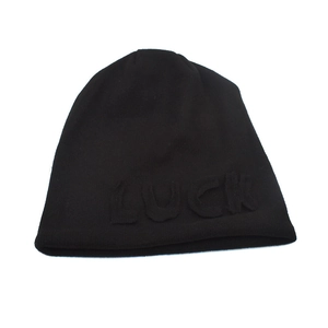 Close-up of black knit beanie featuring embossed LUCK lettering and premium fabric texture