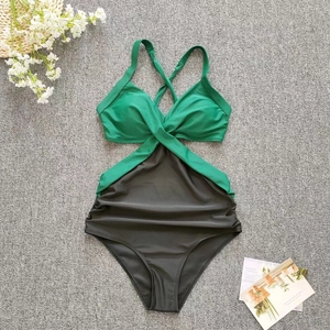 Detail of cross halter neck one-piece swimsuit with green bodice and ruched waist