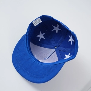 Detail view of the 100% acrylic blue baseball cap showing inner star print and care label