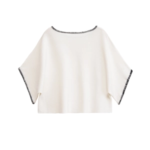 White knit short sleeve top with black embroidered edges and a loose batwing sleeve cut