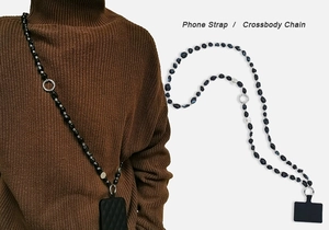 Detailed view of bohemian crossbody phone strap with black irregular beads and metal rings