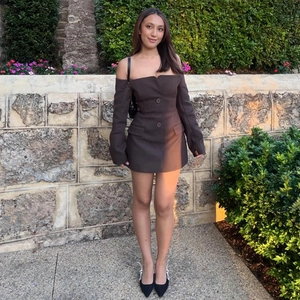 Detail of dark brown off-shoulder mini dress with long sleeves and front buttons
