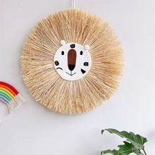 Detail of woven lion wall hanging with straw fringe for Nordic nursery decor