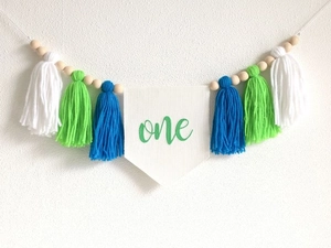 Detail of high chair banner with one embroidery, colorful tassels and wooden beads