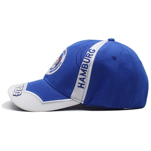 Detail of Hamburg embroidery and crest on navy blue and white cotton baseball cap