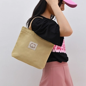 Minimalist khaki canvas tote bag with bear patch for daily commuting and storage