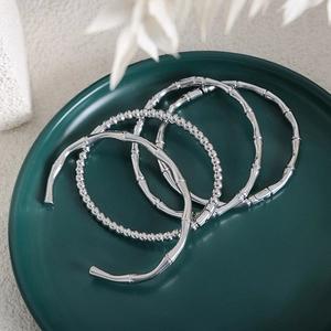 Silver stainless steel bracelet set with bamboo design and beads in a ceramic tray