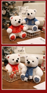 Close-up of plush polar bears wearing embroidered red and blue festive scarves and coats
