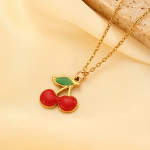 Elegant gold stainless steel necklace featuring red enamel cherry pendant on satin background