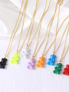 Close-up of colorful resin gummy bear pendants on delicate gold link chains