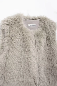Close-up of grey faux fur vest with detailed brand size label on the round neckline