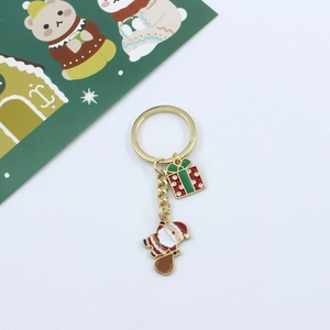 Detail of Christmas keychain with Santa Claus and gift box charms on golden ring