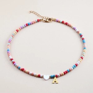 Colorful beaded necklace featuring golden letter A pendant and white shell heart charm