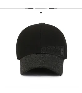 Front view of winter baseball cap featuring black knit fabric and grey ear protection flaps