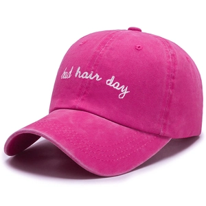 Close-up of rose red washed cotton baseball cap with white Bad Hair Day embroidery