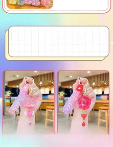 Detailansicht süßer rosa und roter Schlüsselanhänger mit flüssigem Sand und Bubble-Band