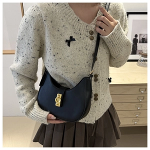 Elegant black crescent hobo bag with vintage gold metal buckle worn by a model