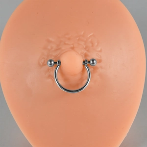 Close-up of G23 titanium U-shaped nipple ring with opal and zirconia on silicone model