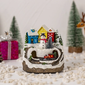 Detail of Christmas resin village with glowing houses, snowmen and micro train tunnel