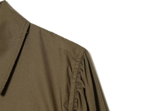 Detail of olive green poplin shirt featuring pleated puff sleeves and neat stitching