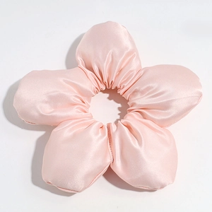 Detailed view of glossy pink satin fabric flower hair tie with five petal design on white