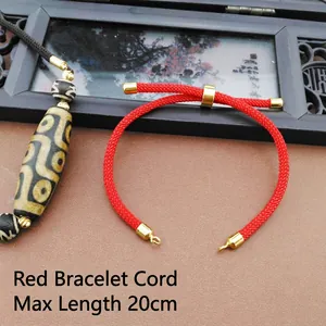 Close-up of adjustable red braided nylon cord for bracelets with gold metal ends and 20cm scale