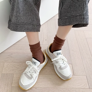 Zapatillas retro blancas y grises con suela de goma y calcetines de algodón caqui