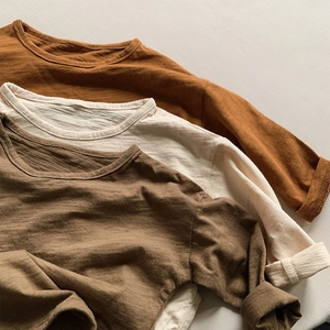 Detail of layered cotton long sleeve shirts in caramel, beige, and olive with slub texture
