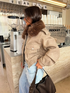 Detail of light brown cropped jacket featuring a warm faux fur collar and metal zipper